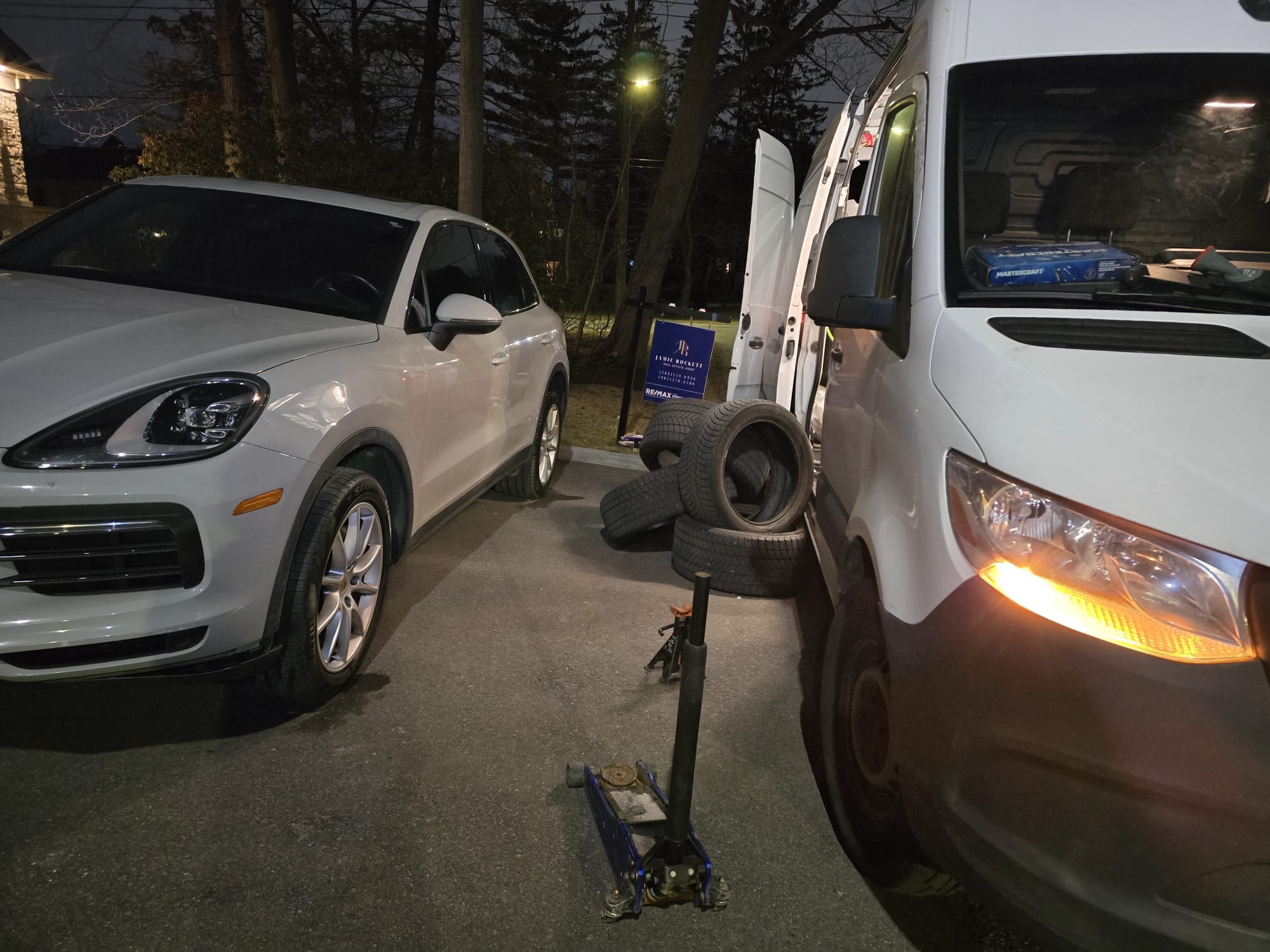 White Porsche Cayenne seasonal tire swap at night — mobile technician with Sprinter van, North York