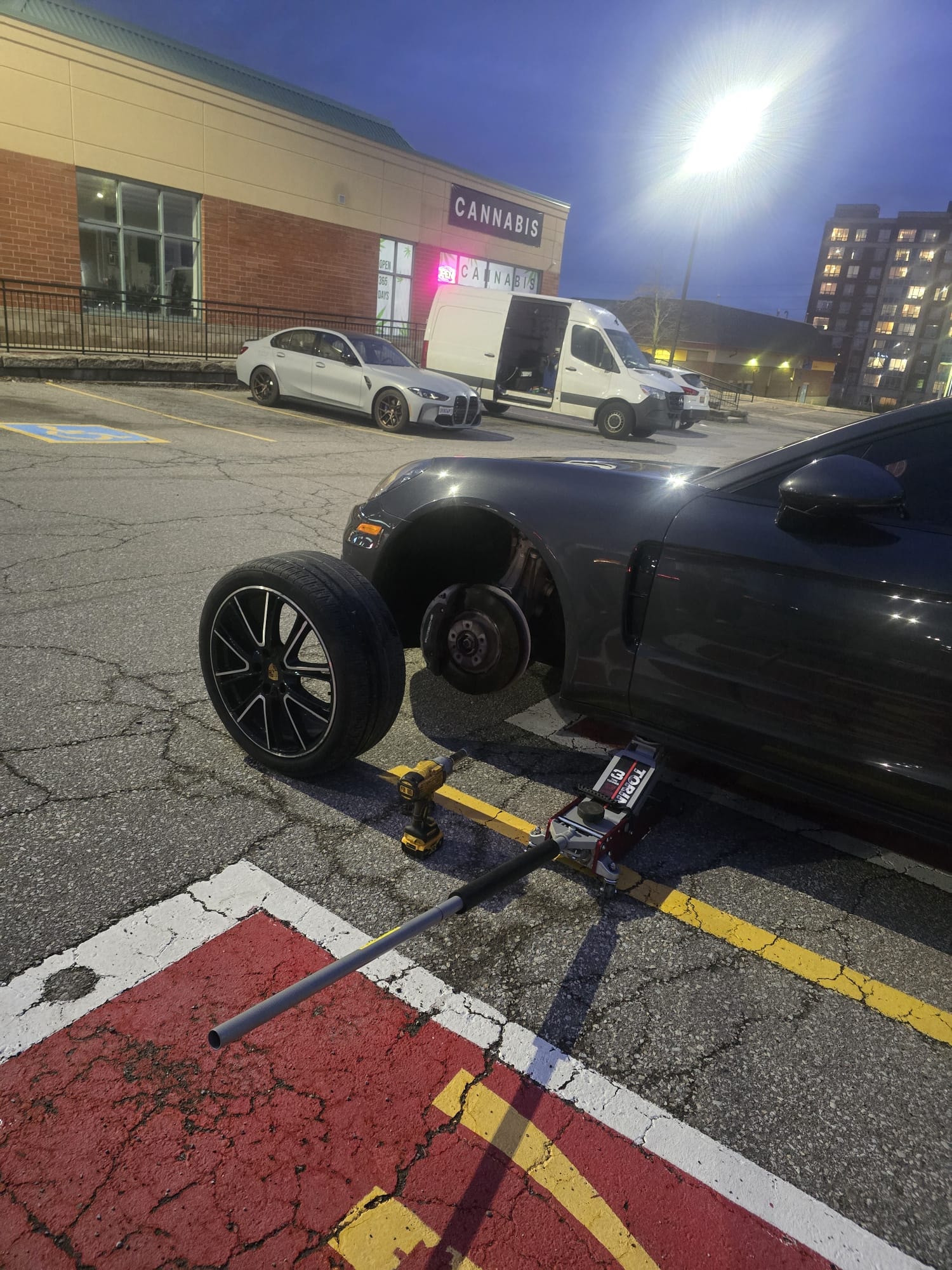 OnSite Tire Toronto technician removing a nail from a tire in a parking lot at night