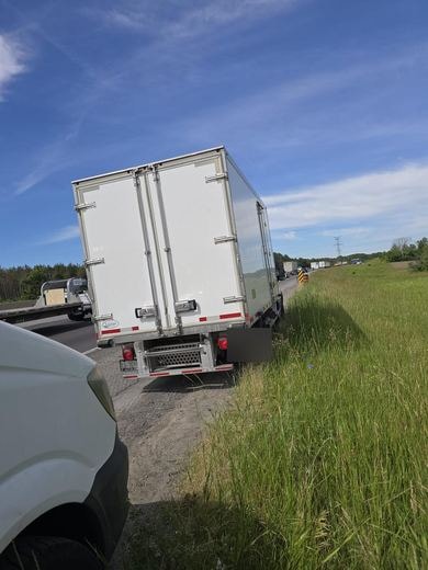 Box truck roadside tire service on the highway shoulder